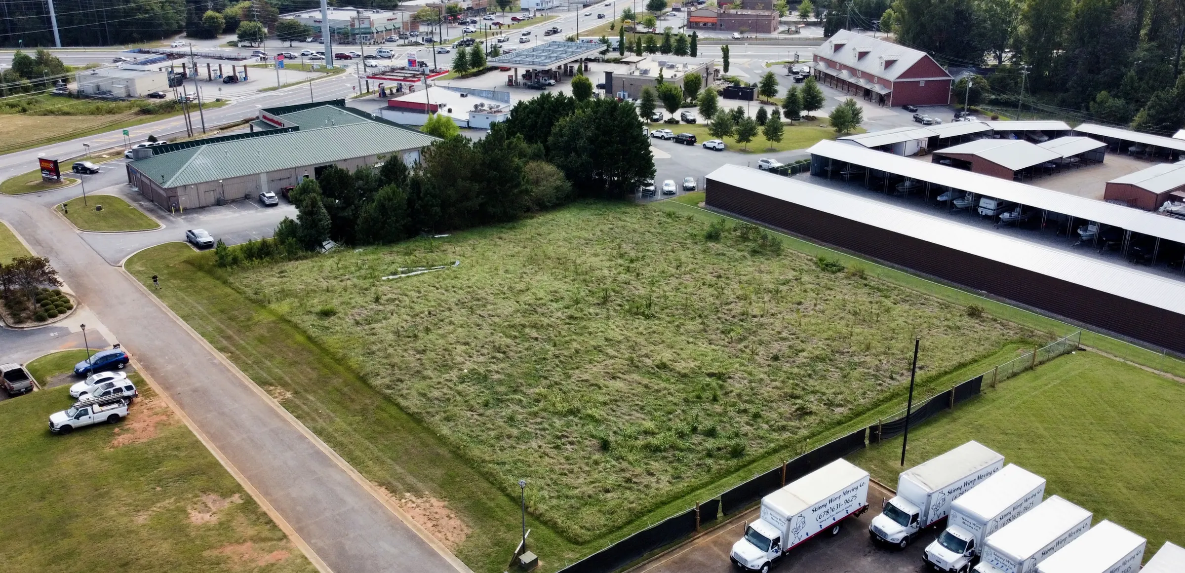 Drone photo of an open commercial tract in Forsyth County, Georgia, bordered by industrial buildings and a truck yard